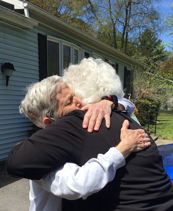 volunteer hugging homeowner